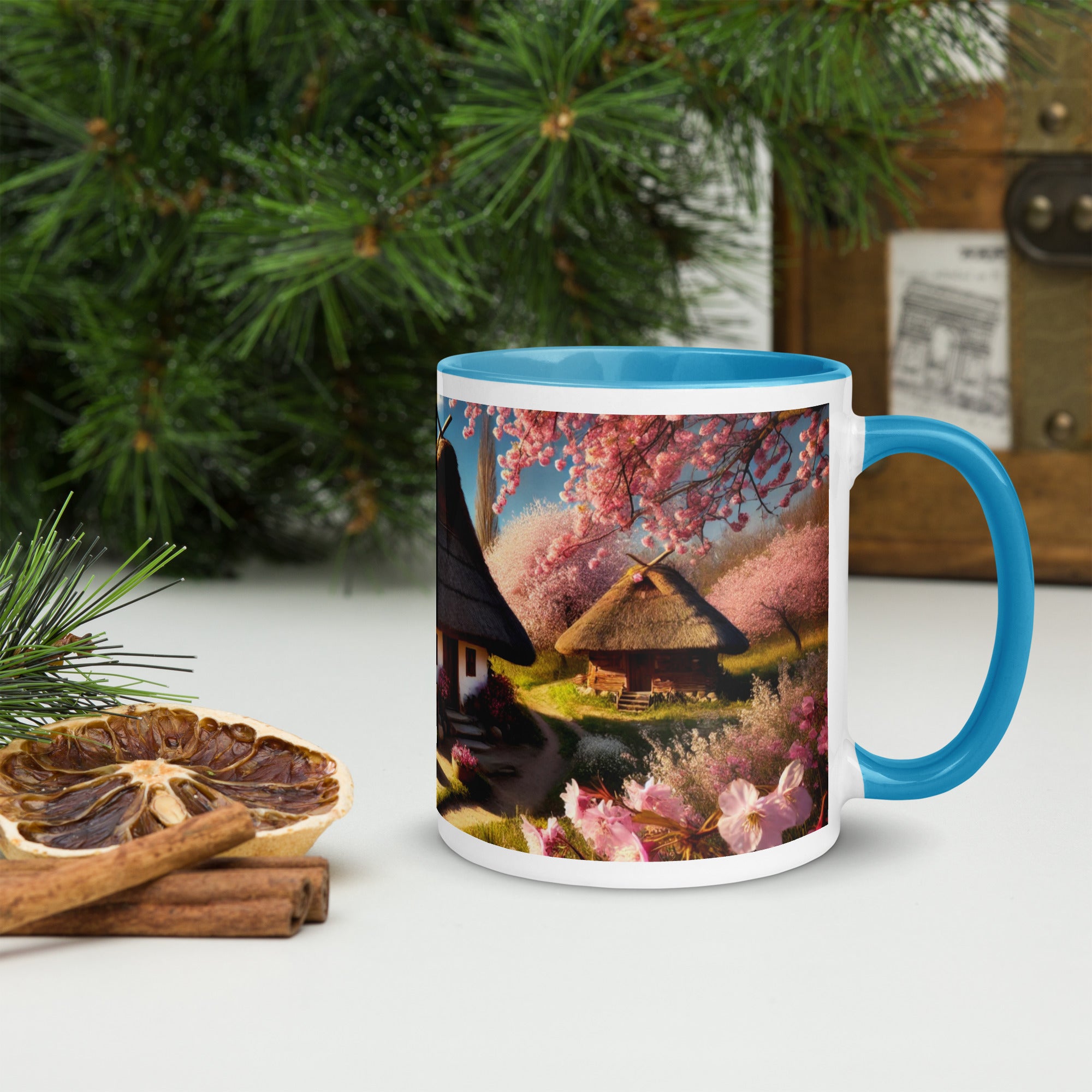 Ceramic mug featuring a Ukrainian cottage with cherry orchard, blue rim and handle, surrounded by greenery and dried citrus.