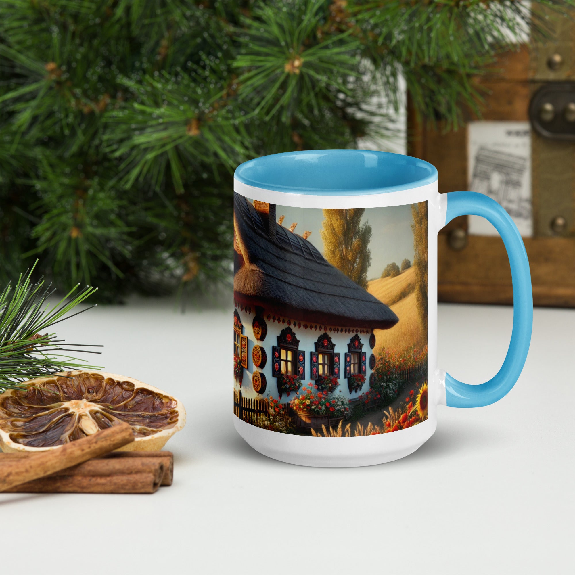 Ceramic mug with Ukrainian cottage and scenic yard design, blue rim and handle, surrounded by rustic decor and greenery.
