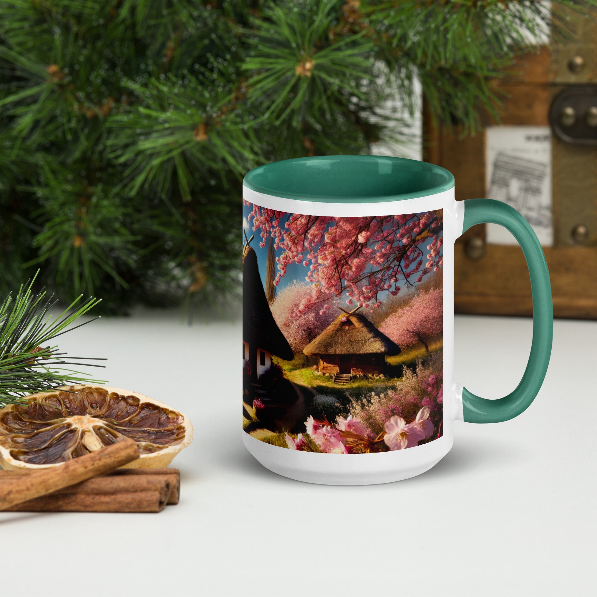Ceramic mug featuring Ukrainian cottage with cherry orchard, green handle and interior, surrounded by dried citrus and pine branches.
