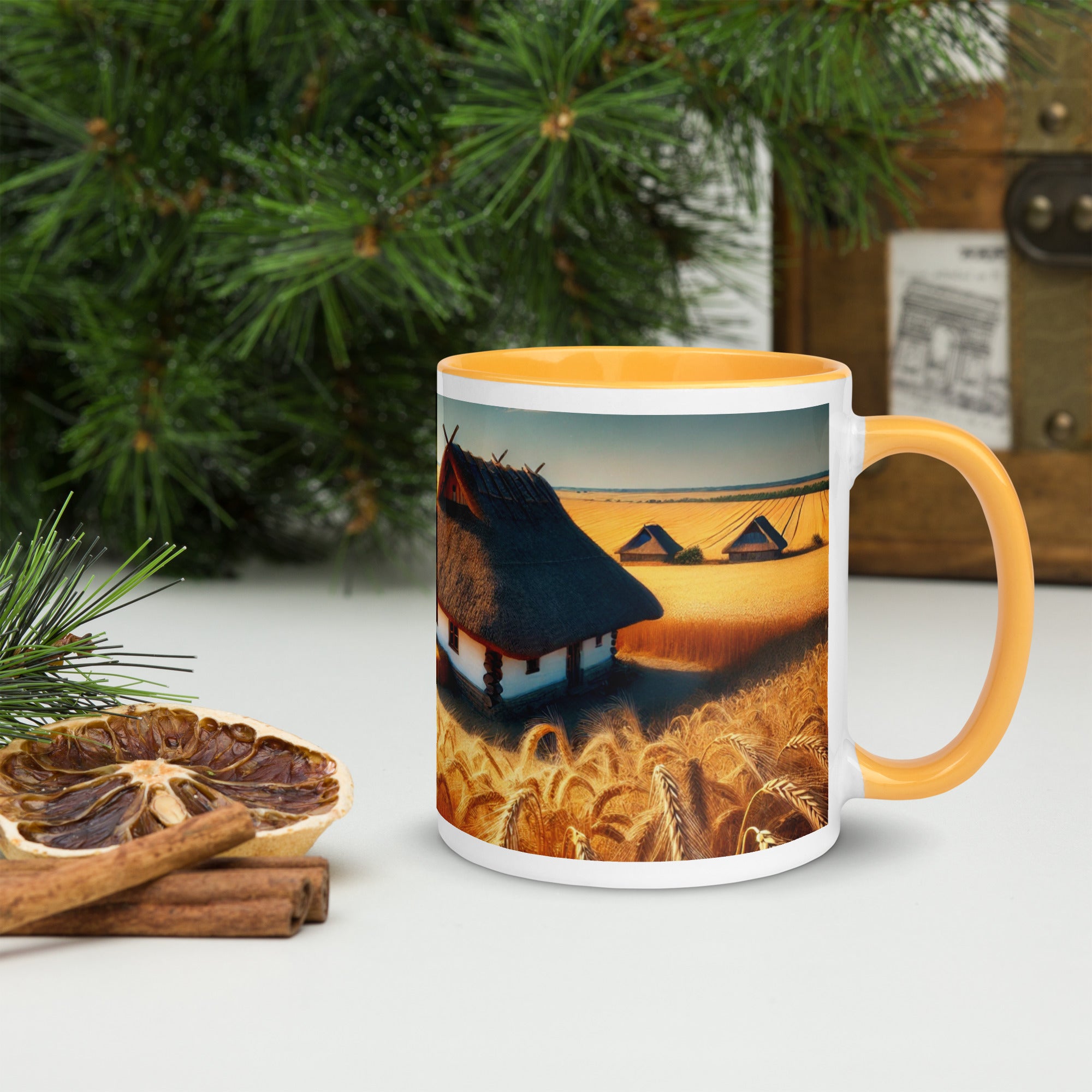 Ceramic mug with Ukrainian cottage and wheat field design, featuring orange rim and handle, on a festive table setting.