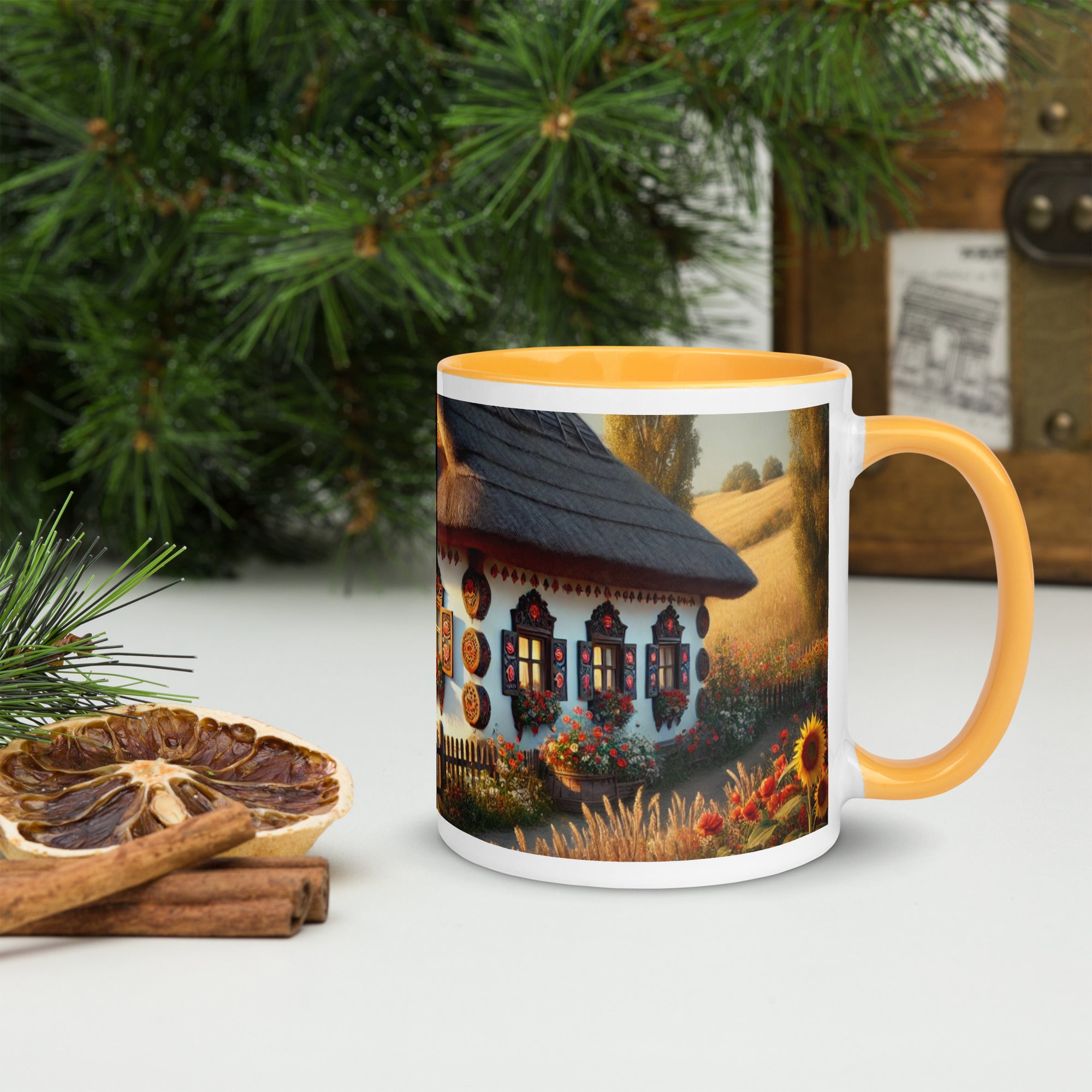 Ceramic mug featuring a Ukrainian cottage with scenic yard, yellow rim and handle, surrounded by pine branches and spices.