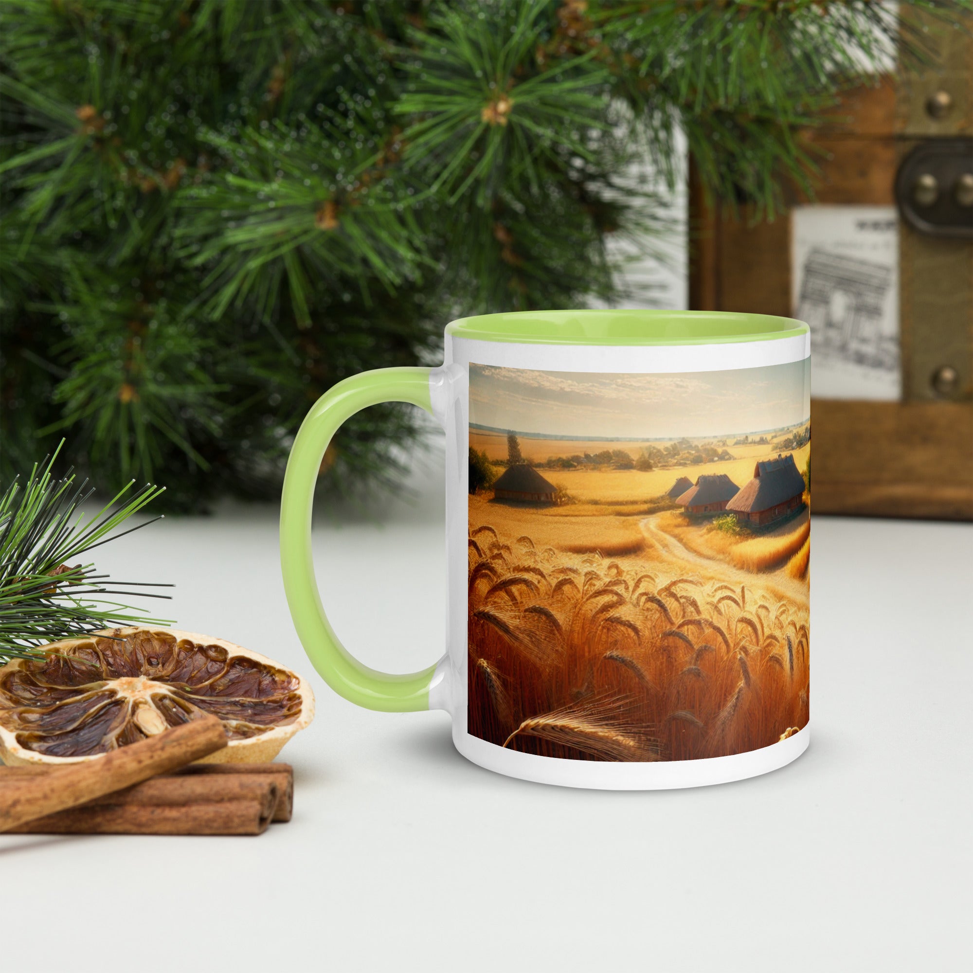 Ceramic mug with Ukrainian cottage and wheat field design, green handle and interior, on a festive table with pine branches.