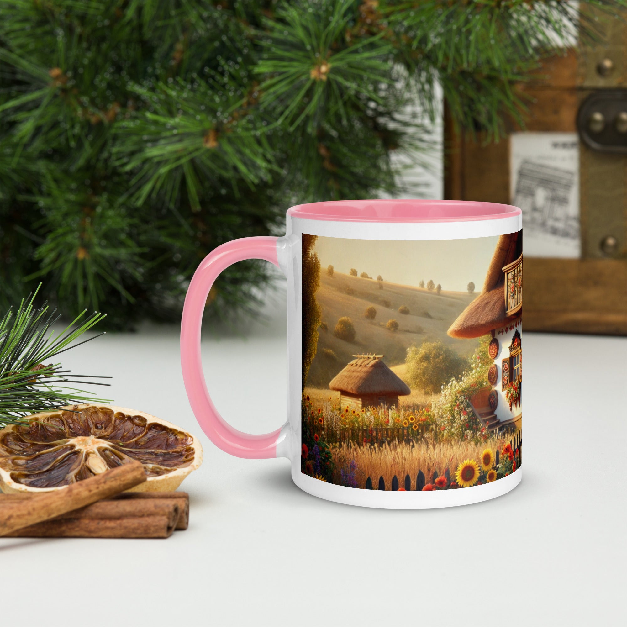 Ceramic mug with Ukrainian cottage and scenic yard design, pink accents, displayed on a table with greenery and dried fruit.