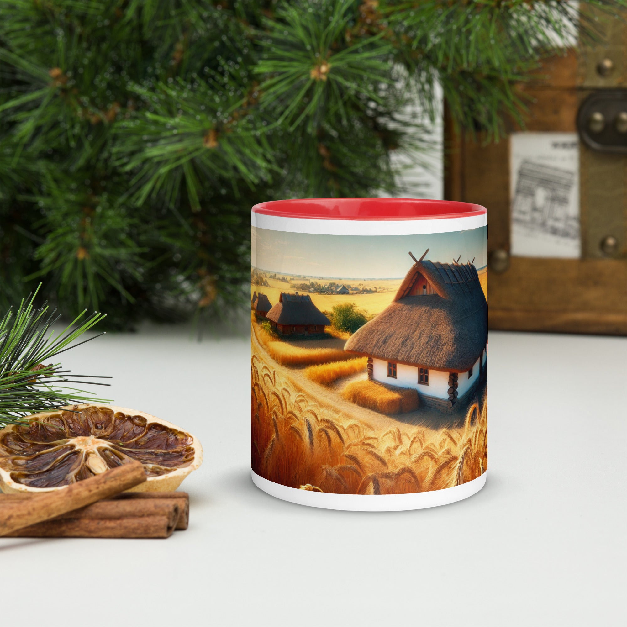Ceramic mug with Ukrainian cottage in wheat field design, featuring a red rim and surrounded by rustic decor.