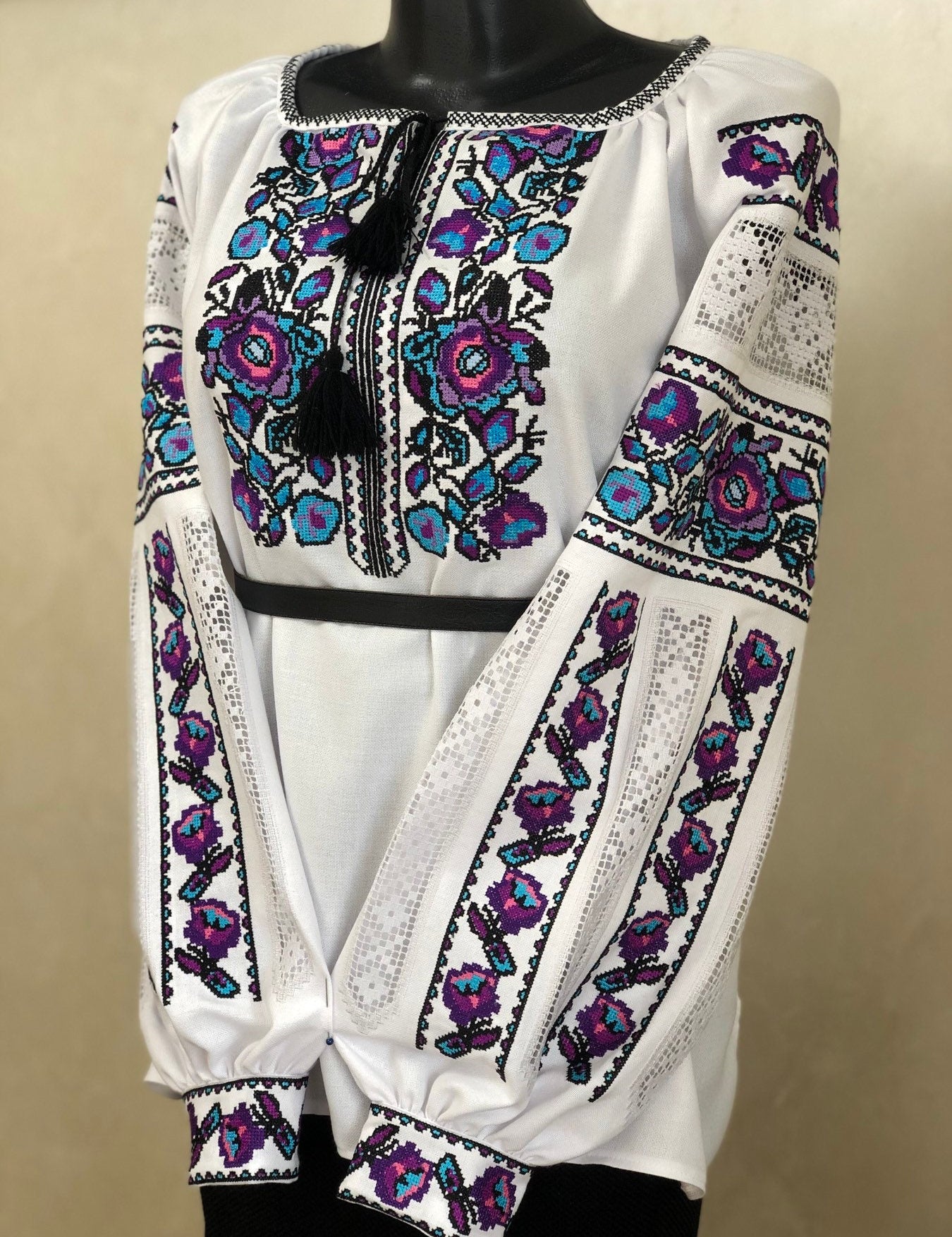 Women's white homespun embroidered vyshyvanka, traditional Ukrainian blouse, with colorful floral cross-stitch pattern.