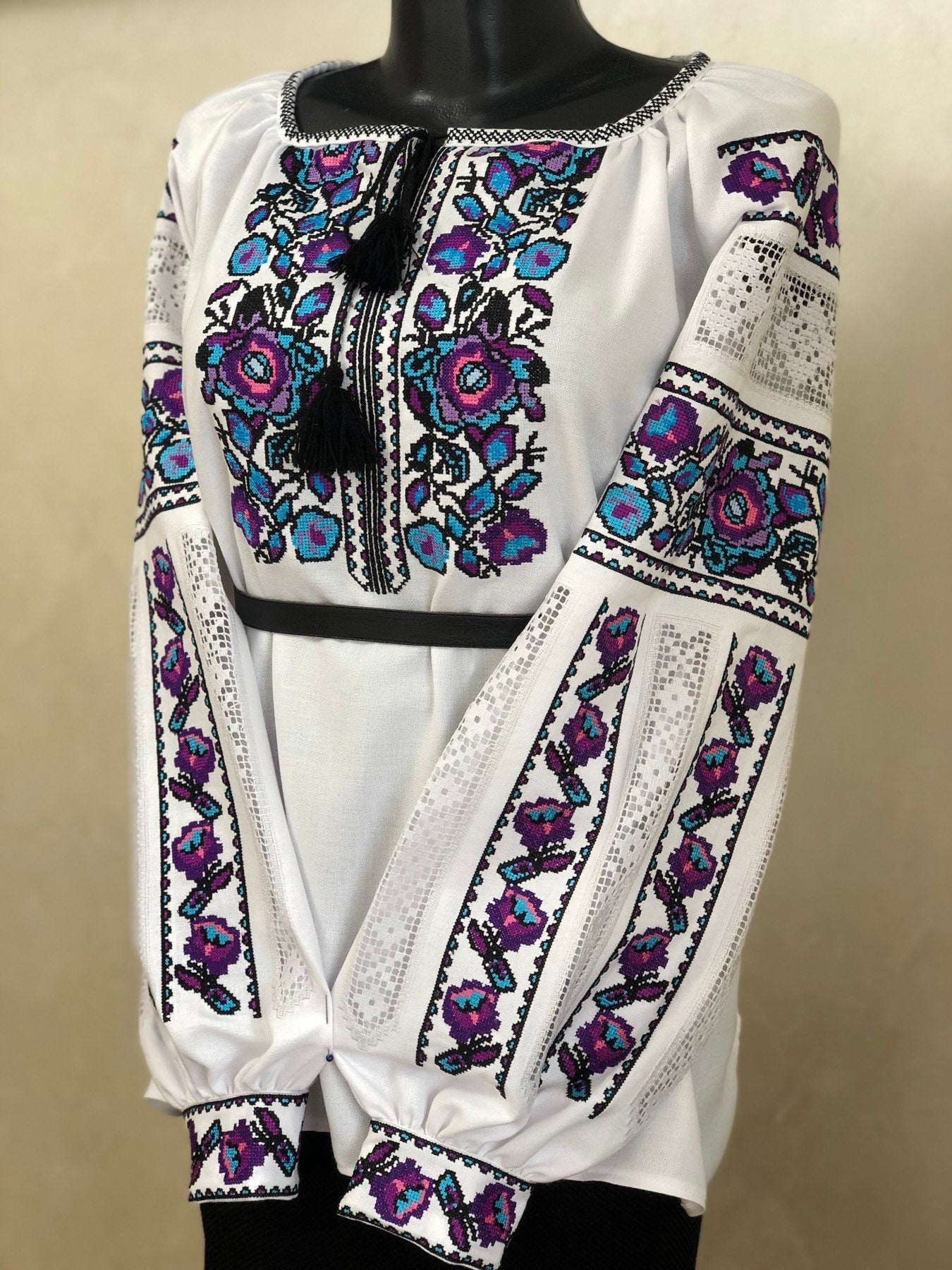 Women's white homespun embroidered vyshyvanka, traditional Ukrainian blouse, with colorful floral cross-stitch pattern.