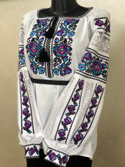 Women's white homespun embroidered vyshyvanka, traditional Ukrainian blouse, with colorful floral cross-stitch pattern.