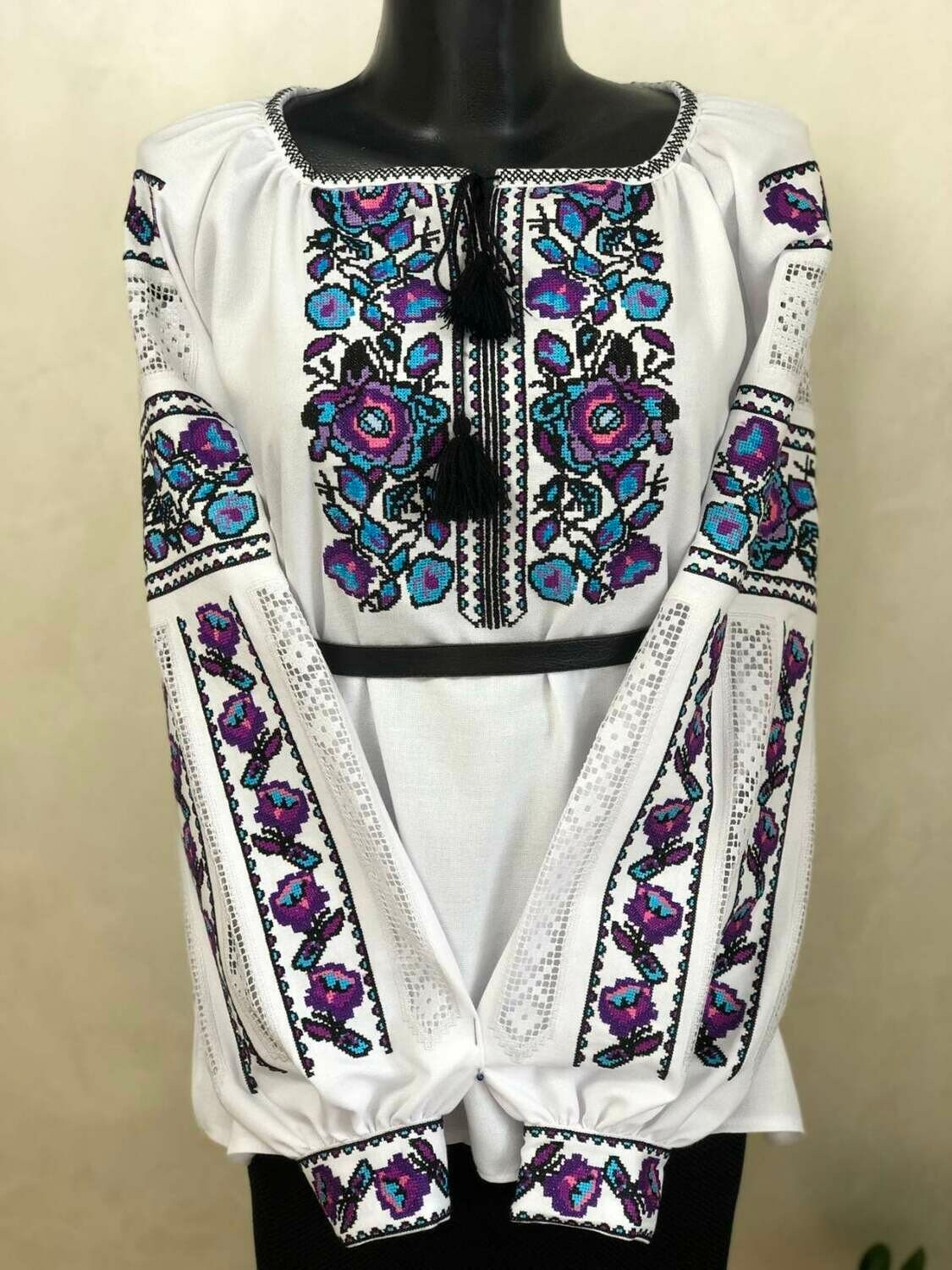 Women's white vyshyvanka with traditional Ukrainian embroidery in purple and blue on homespun fabric.
