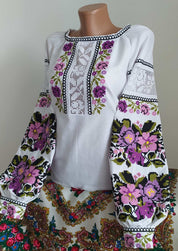 White homespun Vyshyvanka blouse with Ukrainian embroidery, showcasing floral patterns on natural fabric for women.