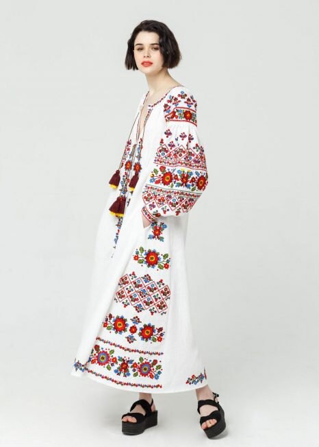 White linen embroidered wedding dress with Ukrainian vyshyvanka, featuring colorful folk patterns and boho style.