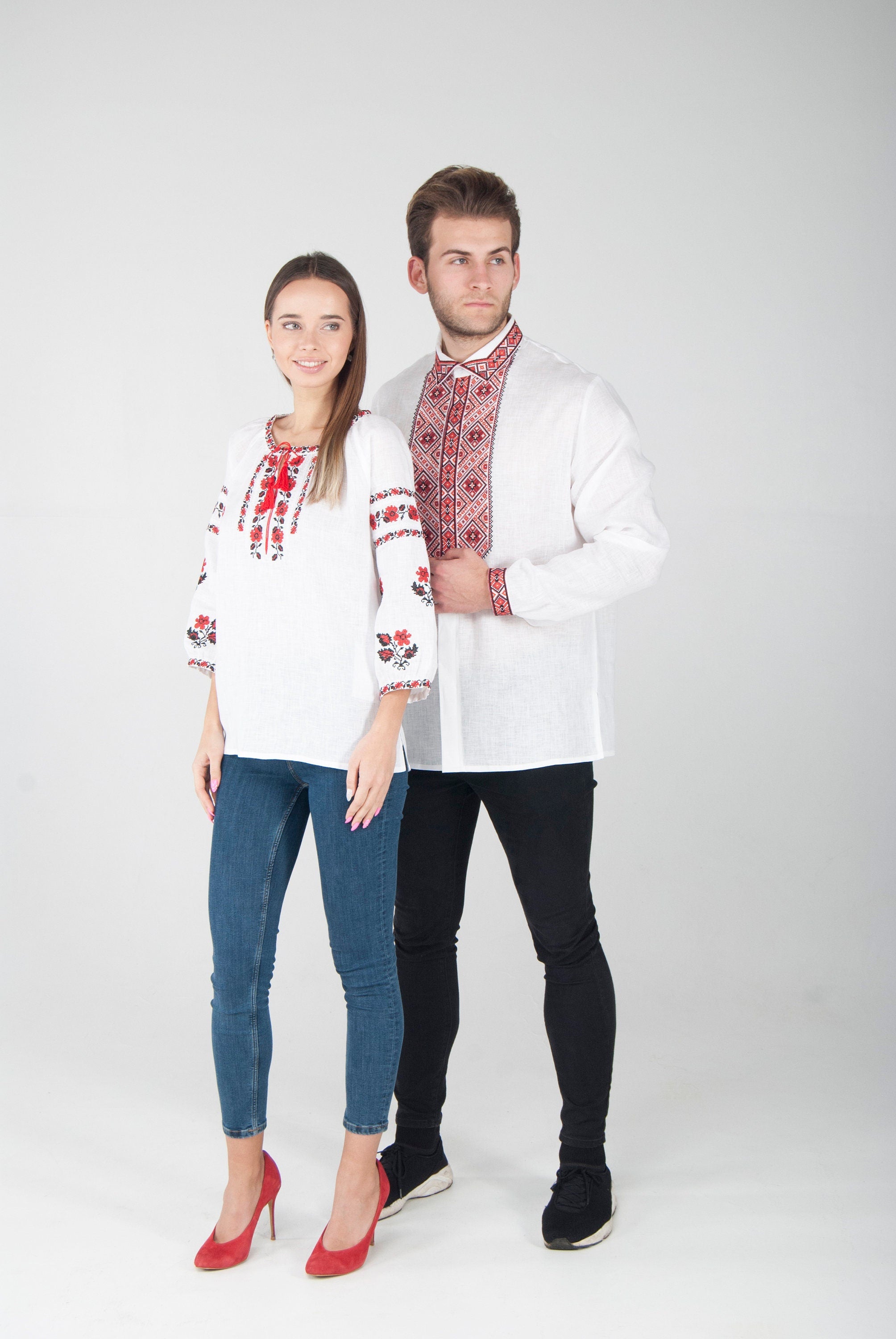 Man and woman wearing Ukrainian embroidered vyshyvanka blouses with red ornament, showing cultural heritage fashion style.