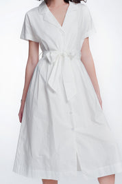Woman wearing a Calviera belted poplin shirt dress in white, showcasing the tailored collar and flattering waist design.