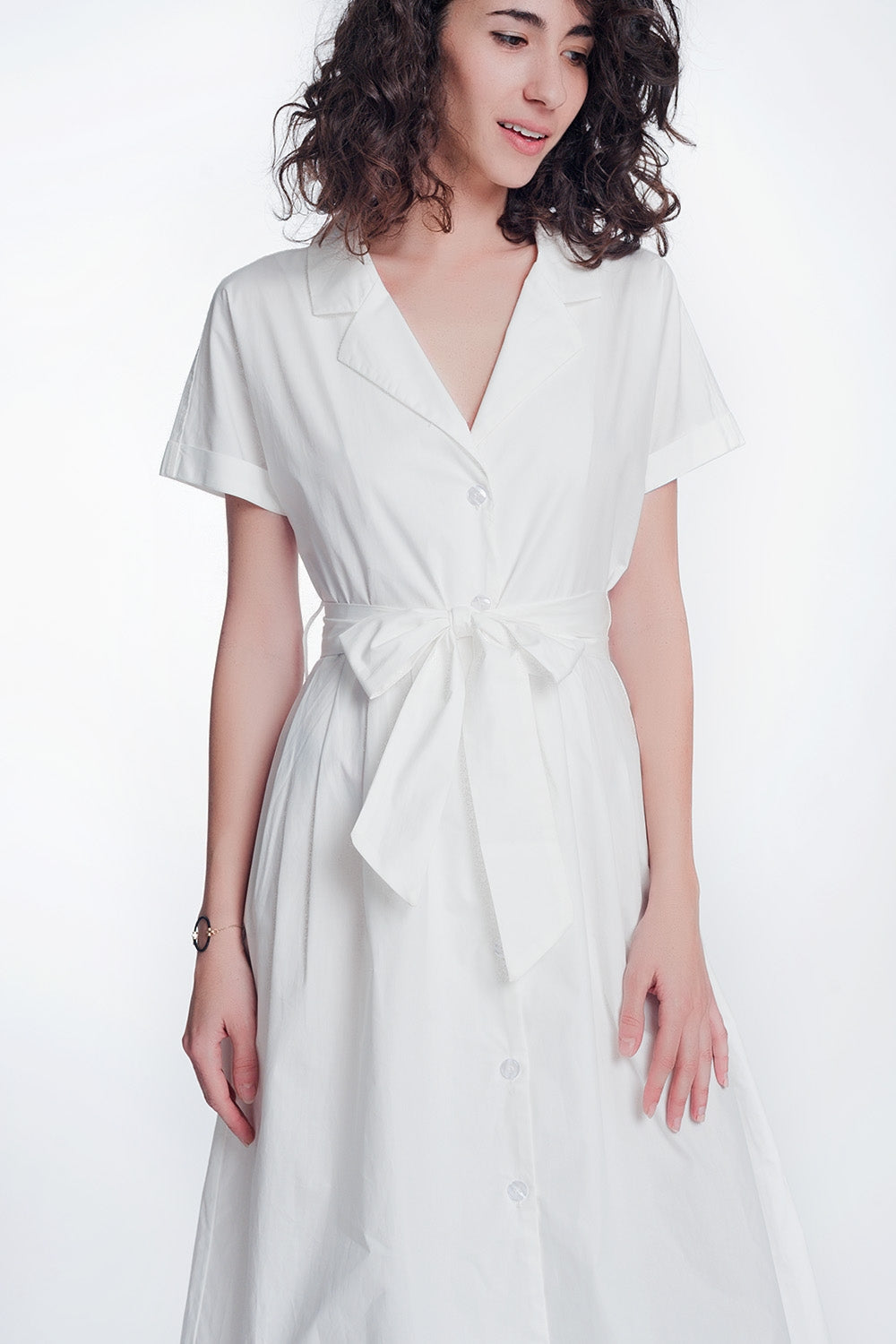 Woman wearing Calviera Belted Poplin Shirt Dress, white cotton with short sleeves and a cinched waist, ideal for warm weather.