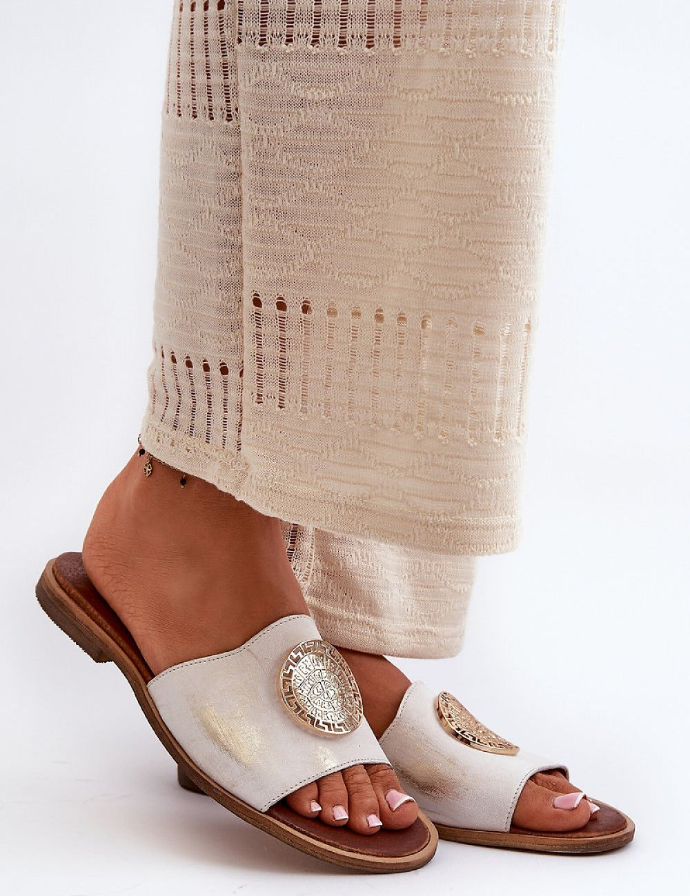 Stylish sandals with gold accents and natural leather, perfect for summer elegance and comfort.