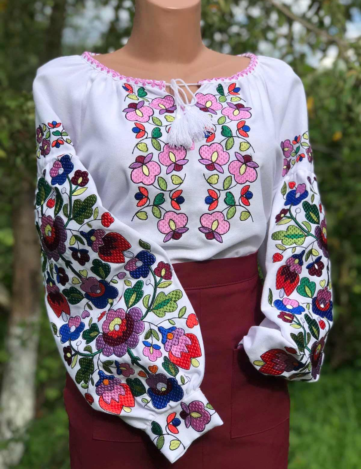 Ukrainian embroidered white blouse with colorful floral patterns on homespun fabric, showcasing traditional folk design.