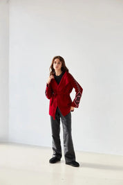 Woman wearing red boho knit cardigan with Ukrainian patterns, oversized wrap design, perfect for winter layering.