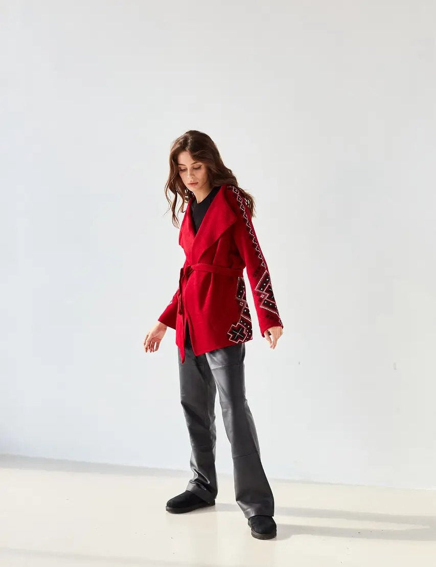 Woman wearing red boho knit cardigan with Ukrainian ornaments, oversized wrap sweater for winter layering.