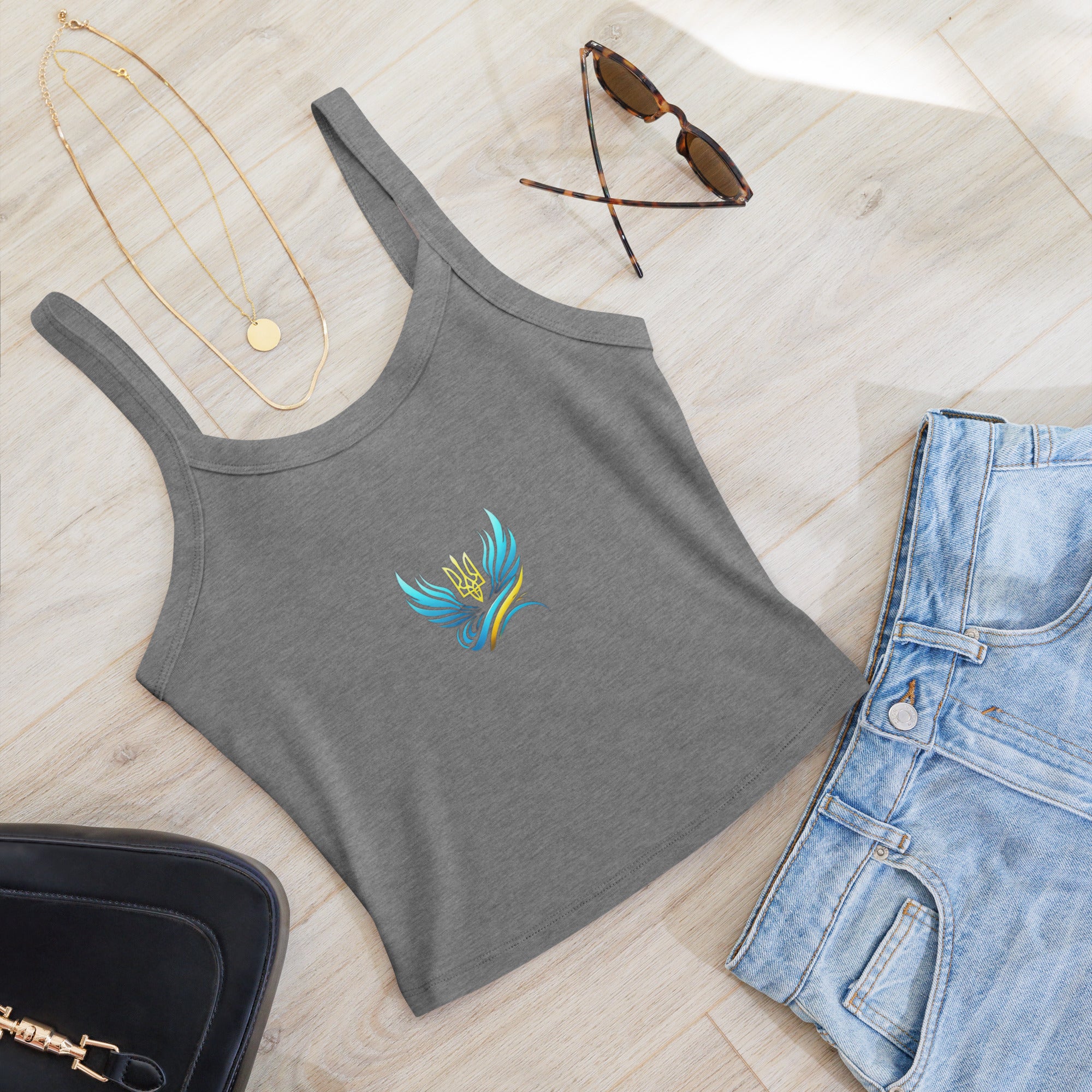 Women's micro-rib tank top from Ukrainian Vibe Trizub Collection displayed with jeans and accessories on a wooden floor.