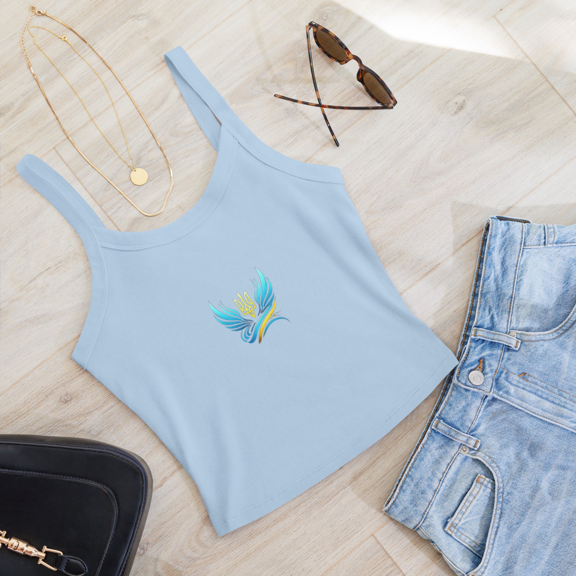 Light blue micro-rib tank top from Ukrainian Vibe Trizub Collection with jeans and accessories, featuring a colorful embroidered design.