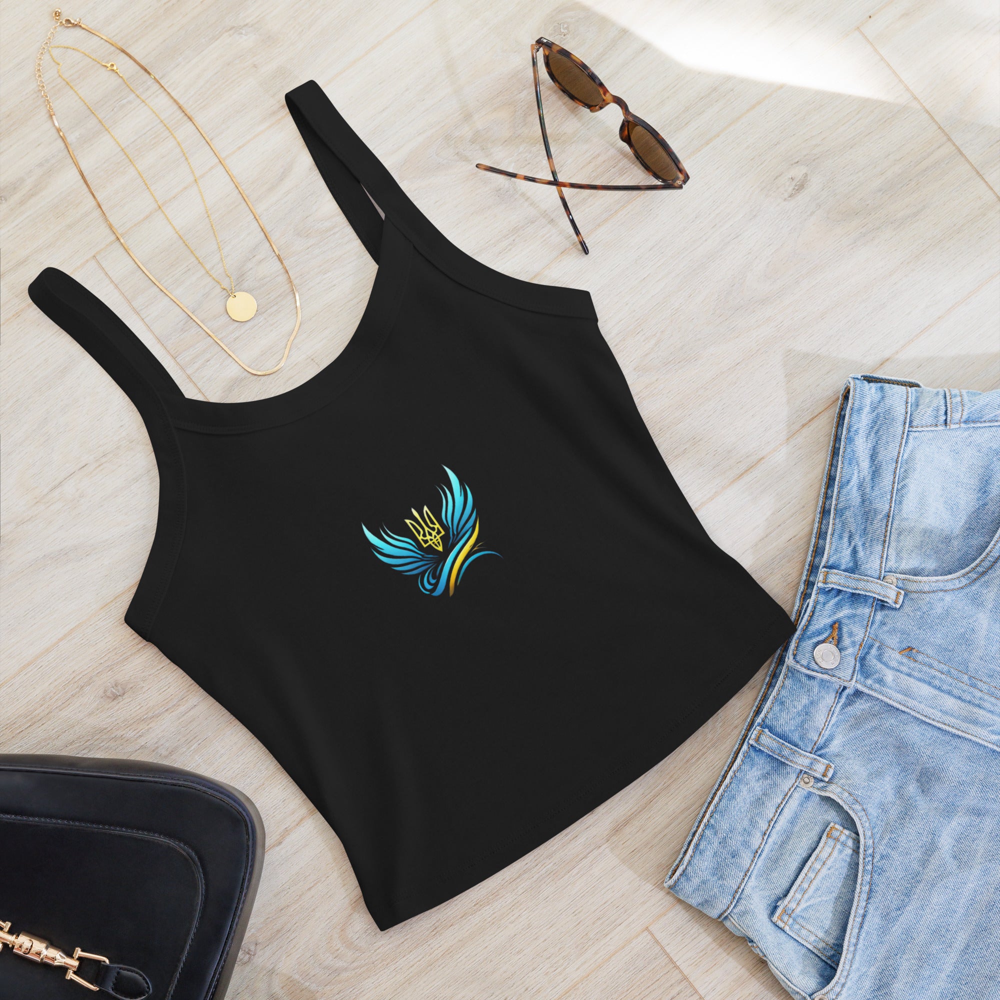 Black micro-rib tank top from Ukrainian Vibe Trizub Collection with vibrant emblem, styled with jeans, necklace, and sunglasses.
