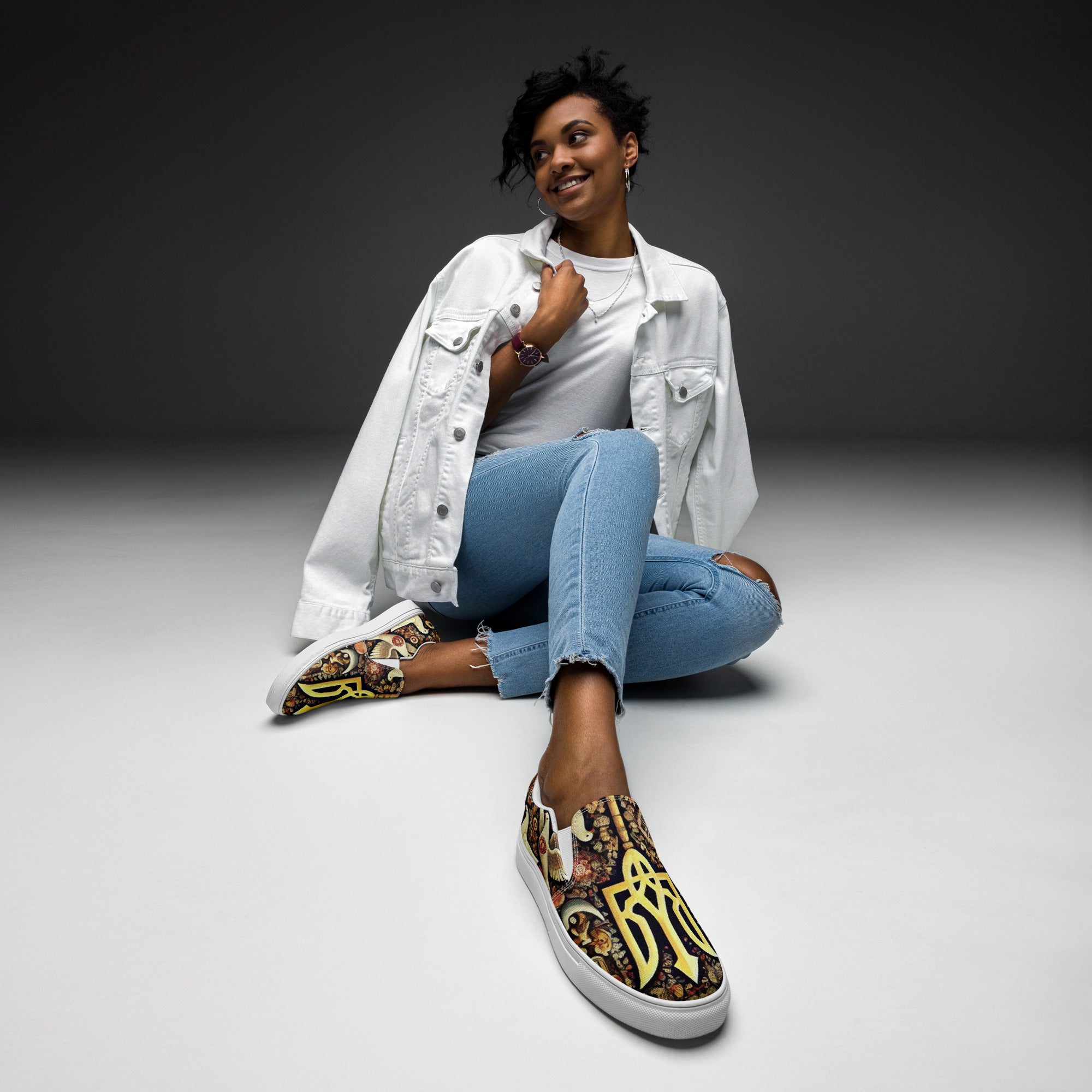 Woman wearing jeans and white jacket, showcasing slip-on canvas shoes with Ukrainian symbolic design.