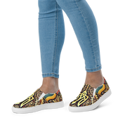 Women's slip-on canvas shoes with Ukrainian symbolic design, colorful pattern, worn with jeans.