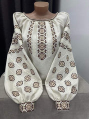 Traditional Ukrainian Vyshyvanka blouse on beige fabric with folk embroidery.