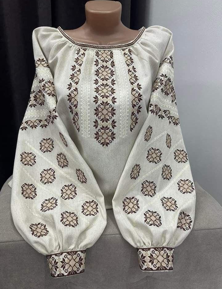 Traditional Ukrainian Vyshyvanka blouse on beige fabric with folk embroidery.