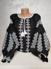 Traditional Ukrainian Vyshyvanka blouse with white embroidery on black fabric, showcasing cultural craftsmanship and folk design.