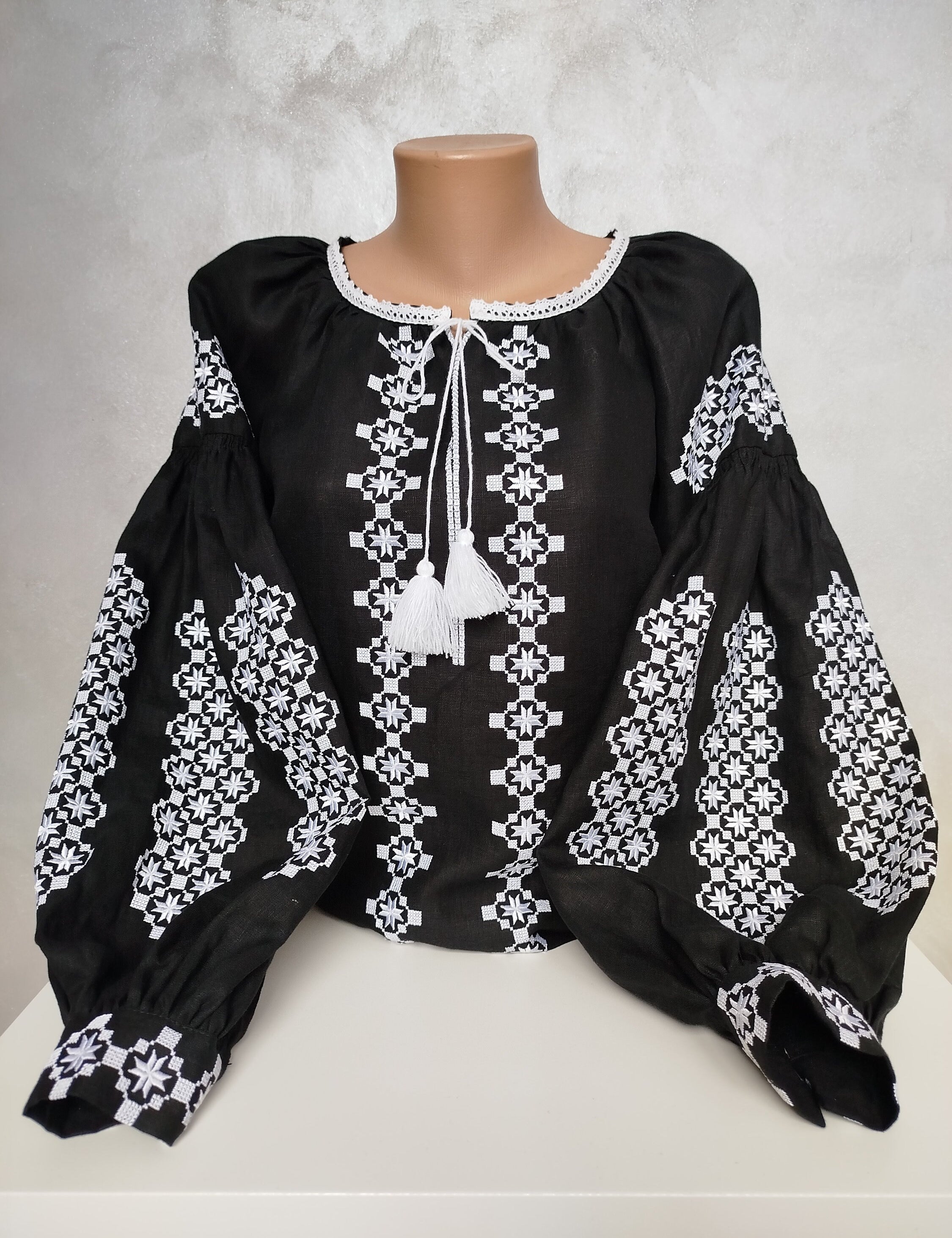 Traditional Ukrainian Vyshyvanka blouse with white embroidery on black fabric, showcasing cultural craftsmanship and folk design.