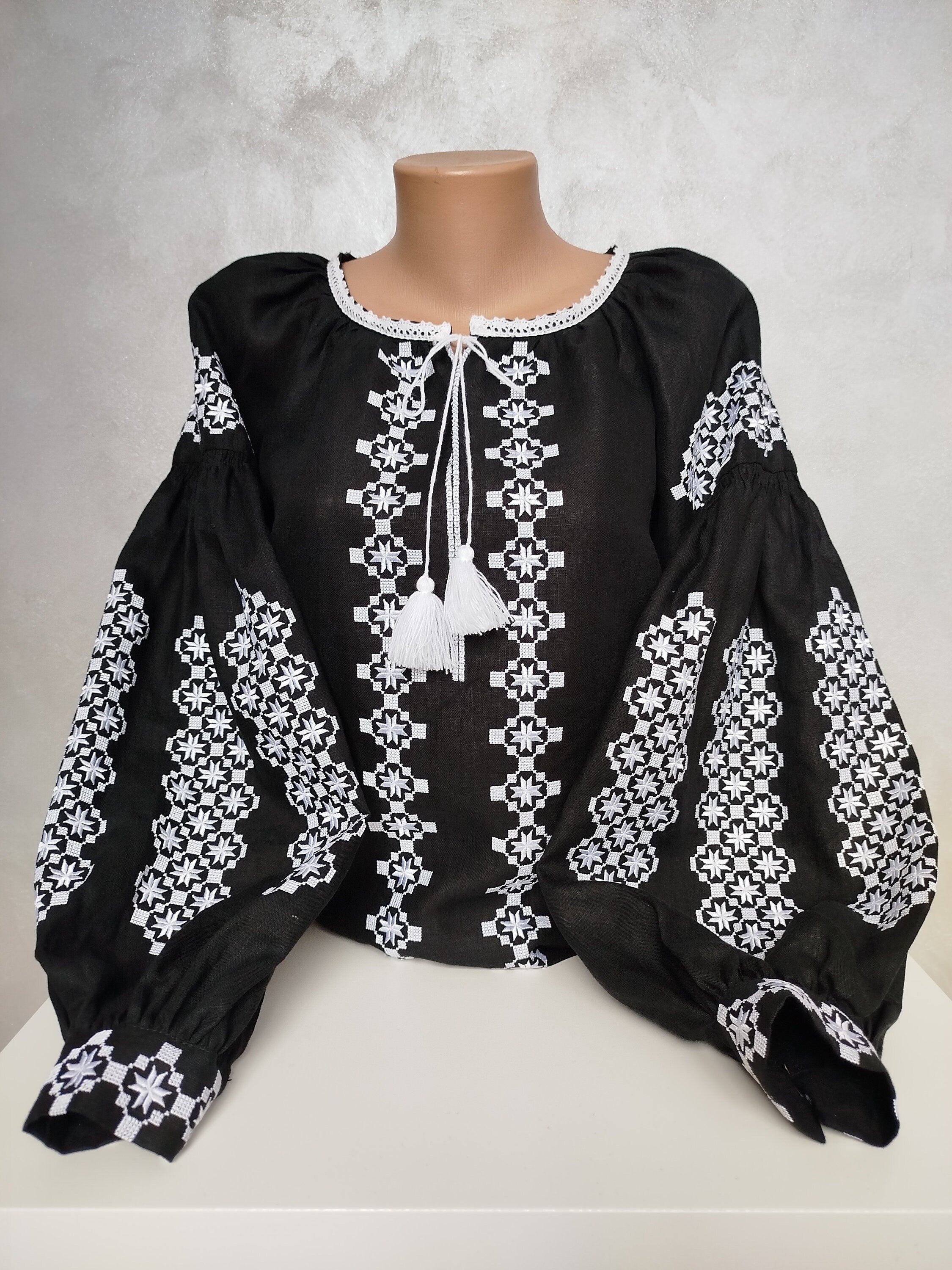 Traditional Ukrainian Vyshyvanka blouse with white embroidery on black fabric, showcasing cultural craftsmanship and folk design.