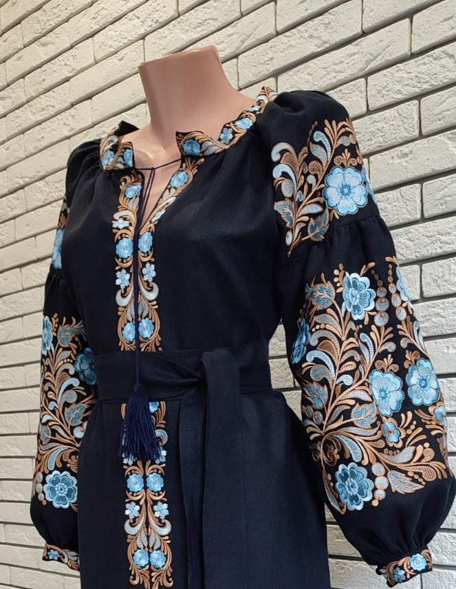 Traditional Ukrainian Vyshyvanka blouse with blue floral embroidery on black fabric, inspired by folk motifs and made with silk threads.