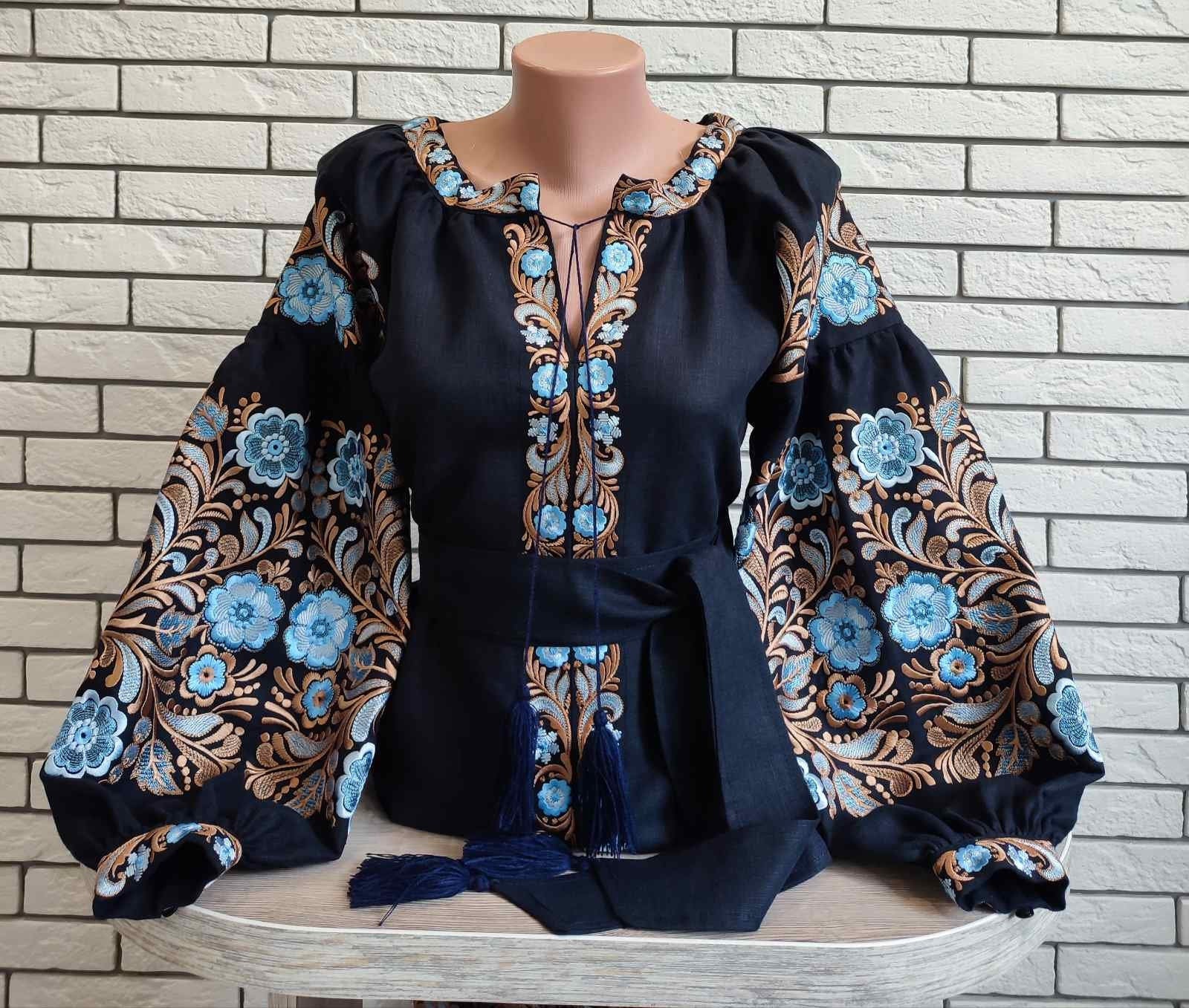 Black Ukrainian vyshyvanka blouse with blue embroidery and folk motifs on homespun fabric.