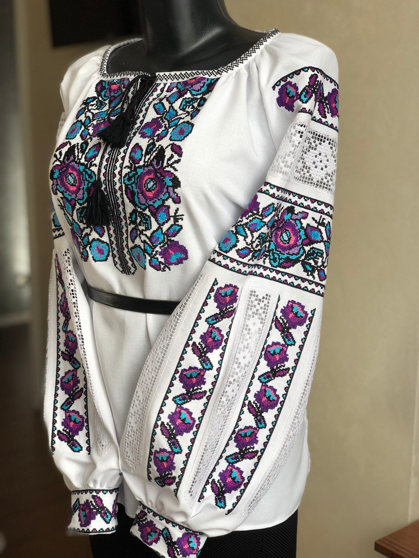 Women's traditional Ukrainian vyshyvanka blouse with colorful floral embroidery on white homespun fabric.