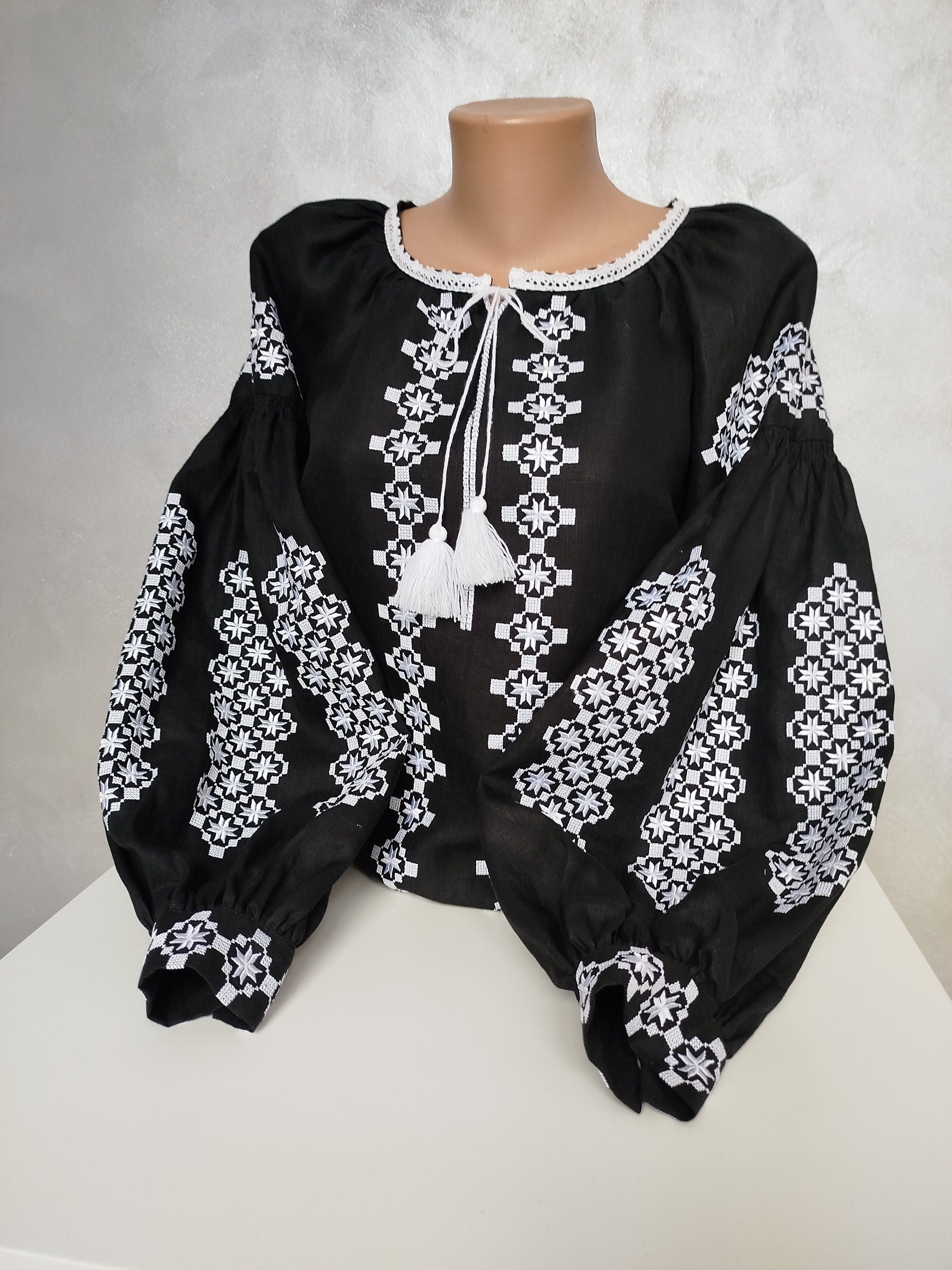 Women's Ukrainian embroidered blouse in black homespun fabric with traditional cross-stitch patterns and silk threads.
