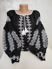 Women's Ukrainian Vyshyvanka with white embroidery on black homespun fabric, featuring traditional folk design and tassels.