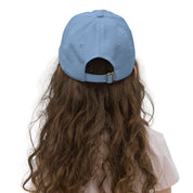 Child wearing a blue youth baseball cap with adjustable strap, perfect for active kids, featuring a comfortable and breathable design.