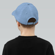 Youth wearing a breathable blue baseball cap with adjustable strap and six ventilation eyelets for active sports and outdoor adventures.