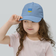 Young girl wearing blue youth baseball cap with Ukrainian Tryzub emblem, breathable bio-washed cotton for active kids.