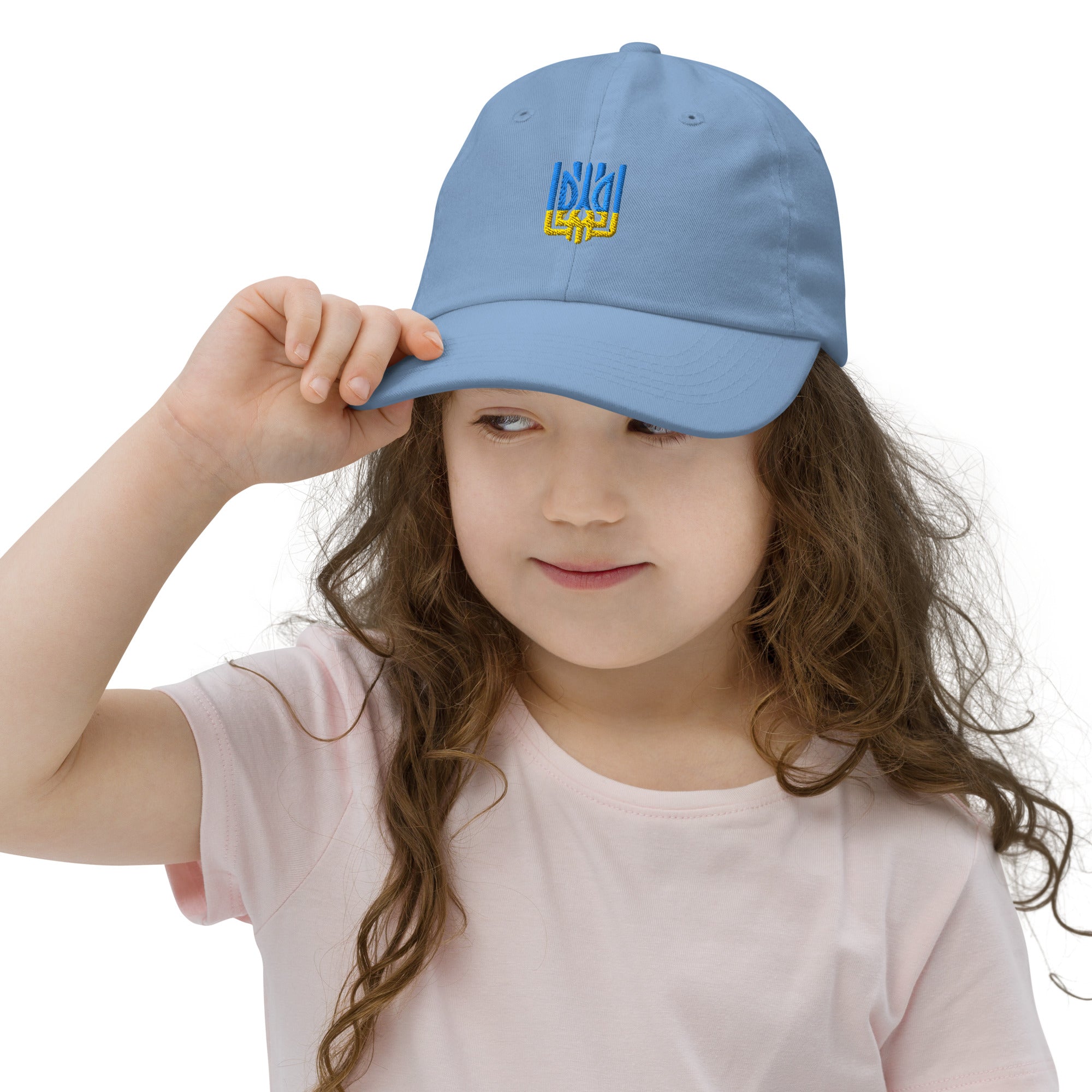 Girl wearing a light blue youth baseball cap with Ukrainian Tryzub emblem, designed for comfort and durability, ideal for active kids.