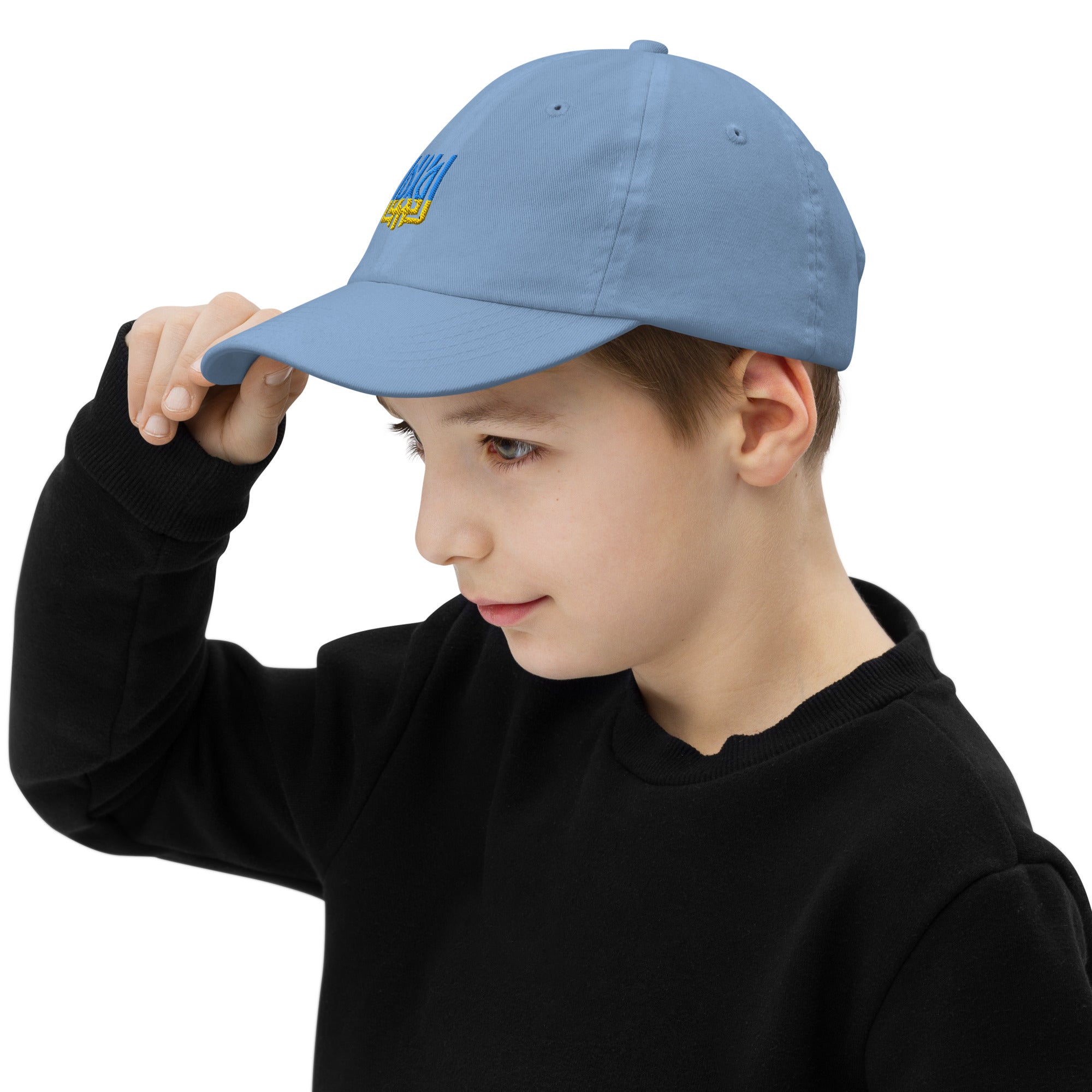 Child wearing a light blue youth baseball cap with Ukrainian Tryzub emblem, showcasing breathability and adjustable fit, ideal for active kids.