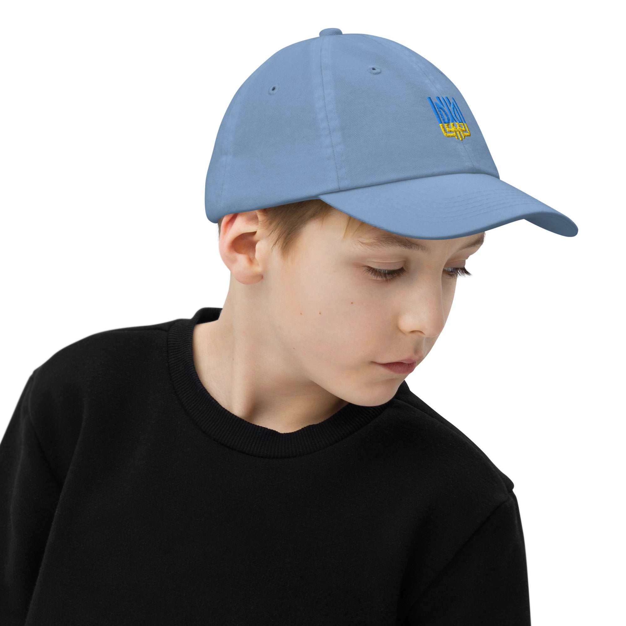 Child wearing a blue youth baseball cap with Ukrainian Tryzub emblem, breathable and adjustable for active kids' outdoor adventures.