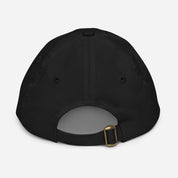 Back view of a black youth baseball cap with adjustable strap and ventilation eyelets, made from 100% bio-washed chino cotton twill.