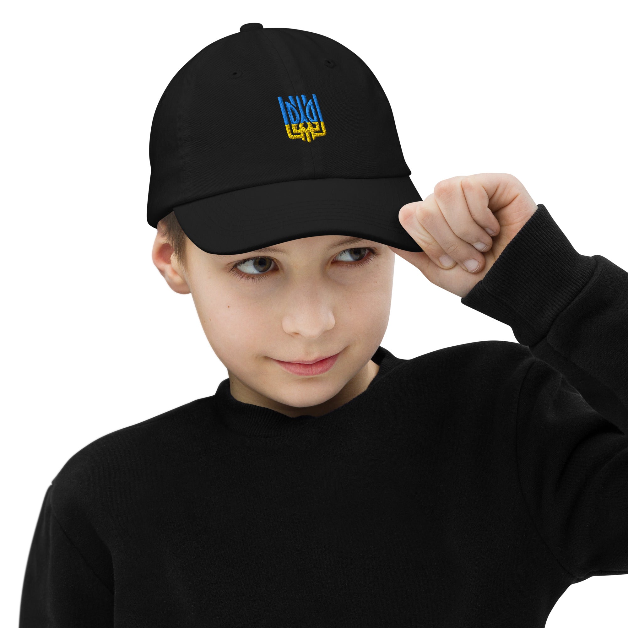 Youth wearing black baseball cap with Ukrainian Tryzub emblem, breathable and adjustable for active kids.
