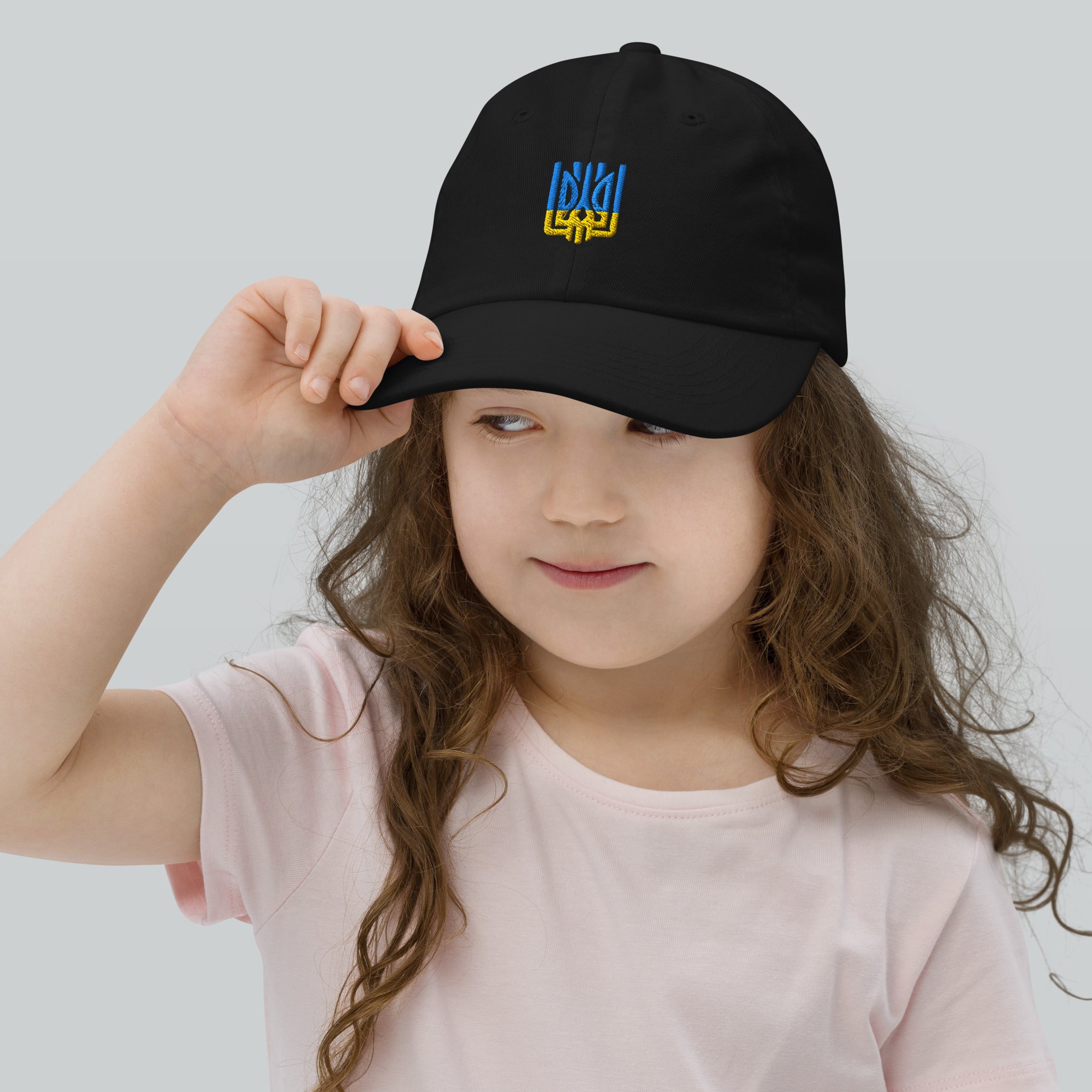 Youth baseball cap with Ukrainian Tryzub emblem, breathable and adjustable, worn by a child, ideal for sports and outdoor activities.