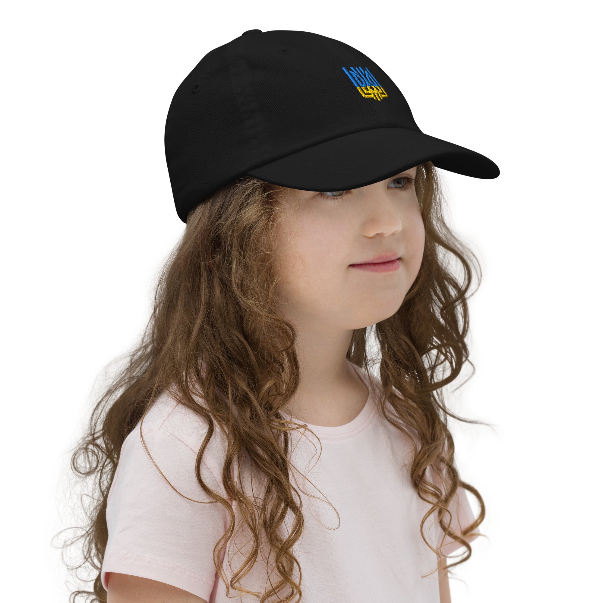 Girl wearing a black youth baseball cap with Ukrainian Tryzub emblem, designed for active kids, featuring breathable, adjustable chino cotton twill.