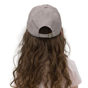 Back view of youth baseball cap with adjustable strap worn by child, ideal for outdoor activities, features Ukrainian Tryzub emblem.