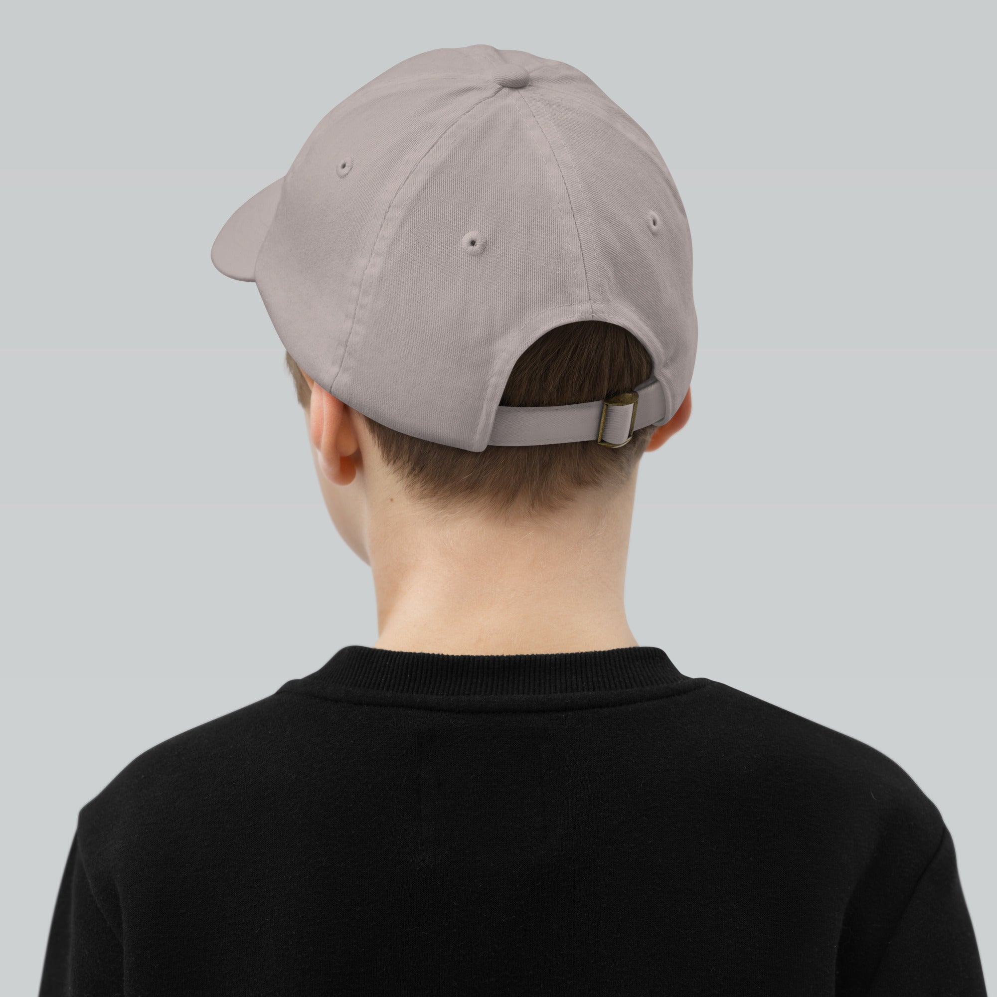Back view of a child wearing an adjustable baseball cap, featuring six ventilation eyelets, perfect for outdoor activities.