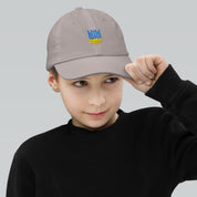 Child wearing a youth baseball cap with Ukrainian Tryzub, adjustable for fit, breathable design ideal for active kids and outdoor play