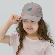 Child wearing a youth baseball cap with Ukrainian Tryzub emblem, breathable and adjustable for active kids. Ideal for outdoor activities.